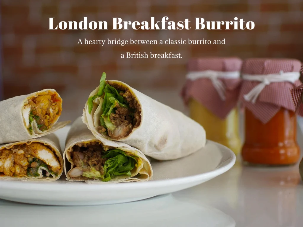 A toasted London breakfast burrito sliced open to reveal Cumberland sausage, crispy bacon, scrambled eggs, and baked beans.