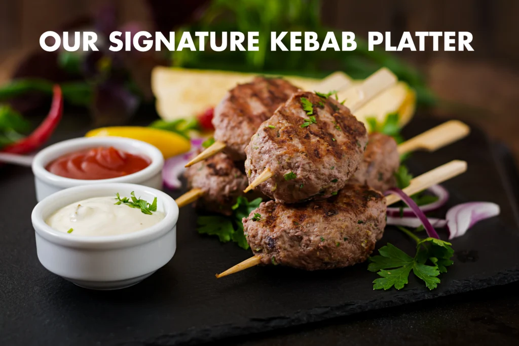 Groupee44 1 Juicy char-grilled Lamb Kofta kebabs on skewers, drizzled with creamy cucumber mint yogurt sauce and garnished with fresh herbs on a rustic platter.