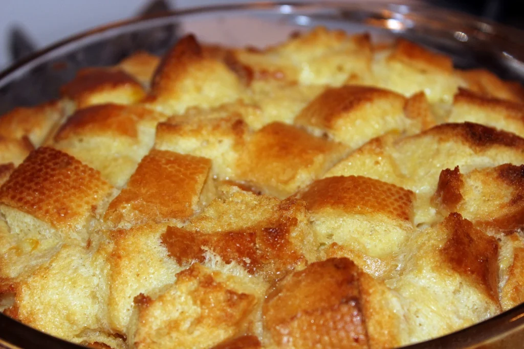 Classic bread and butter pudding with golden crust and scattered raisins.