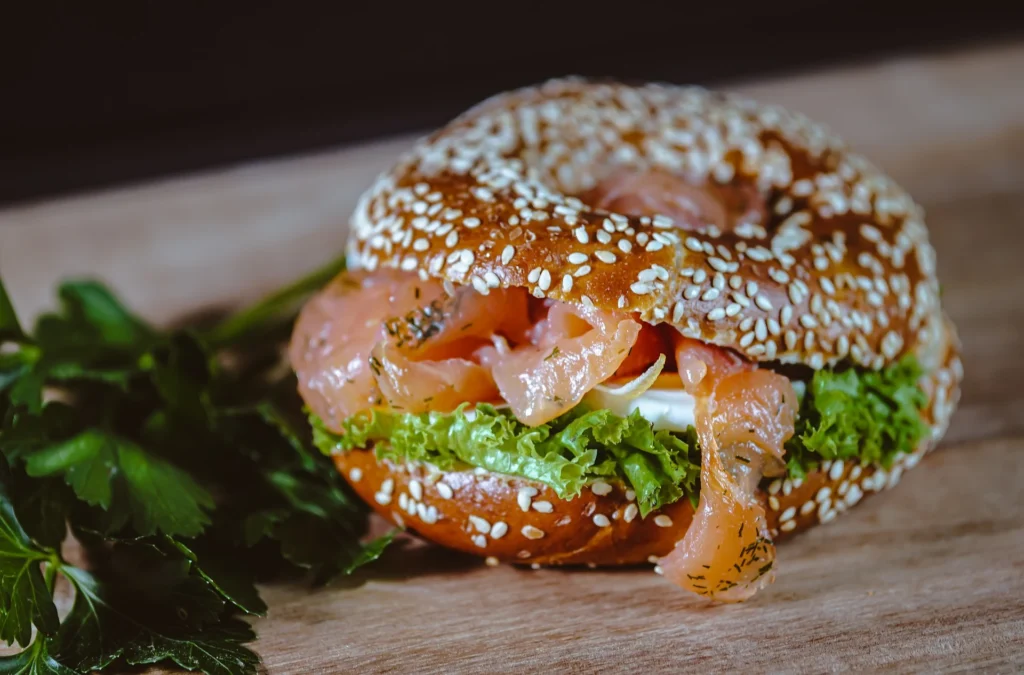 A Smoked Salmon and Cream Cheese Bagel topped with fresh dill, capers, and red onion.