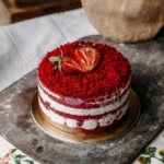 Side view of a classic Victoria Sandwich showing two even layers of golden sponge cake with a visible layer of cream and jam.