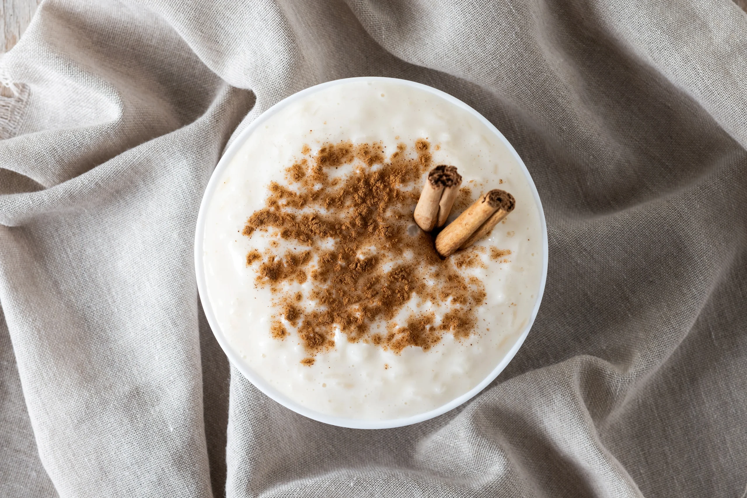 A spoonful of thick, vanilla-scented rice pudding showing the tender grains and creamy texture.