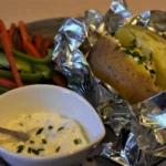 Perfectly baked jacket potato with Heinz-style beans and grated cheddar, a classic British lunch recipe.