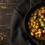 Close-up of a nourishing chickpea curry served over fluffy quinoa with roasted sweet potato cubes and fresh cilantro.