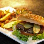 Ploughman's platter featuring a pork pie, pickled onions, gala apple slices, and a dollop of English mustard.