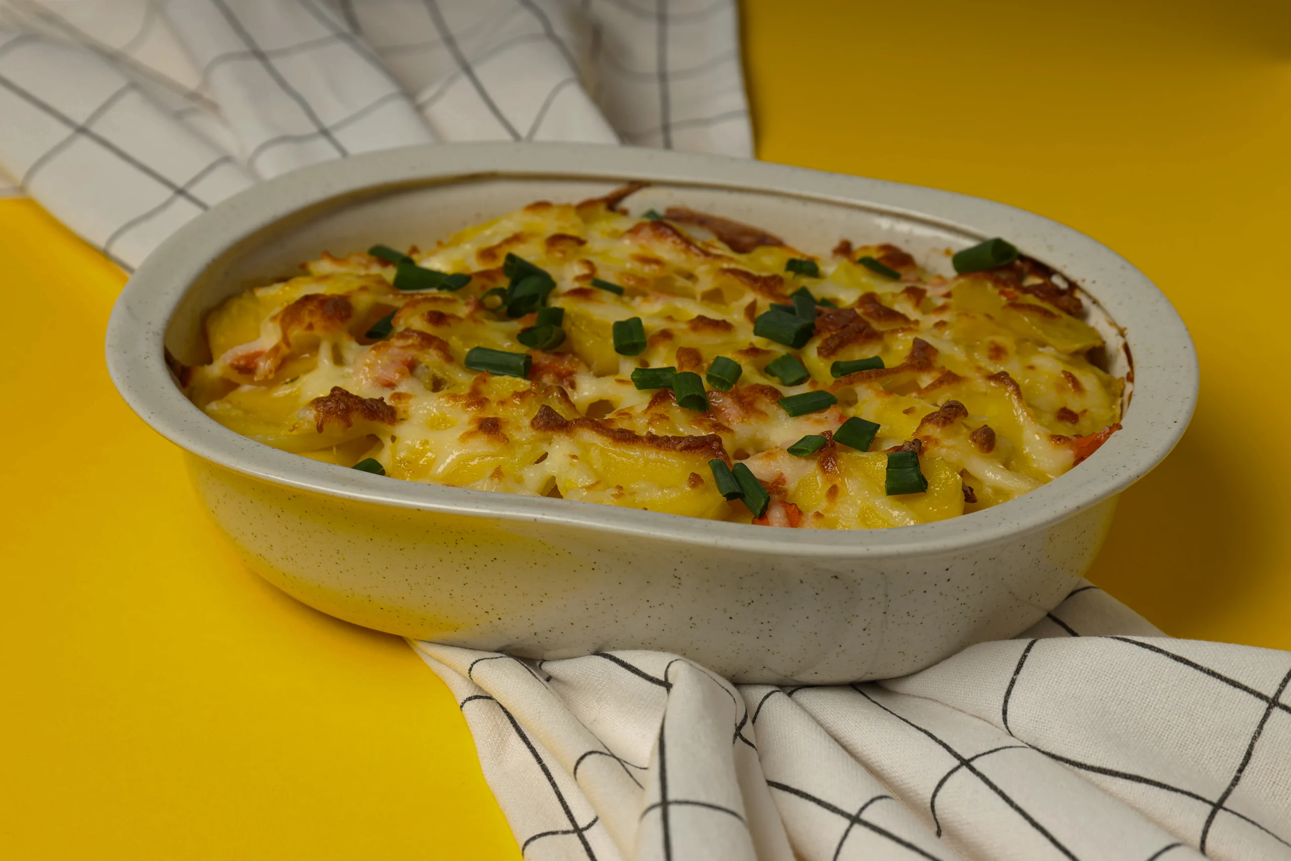 Individual ceramic pie dish with a flaky crust, revealing a creamy chicken and leek filling, paired with smooth buttery mash.