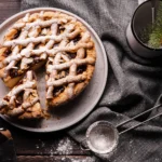 Classic English Banoffee Pie topped with shaved dark chocolate and a drizzle of caramel on a white dessert plate.
