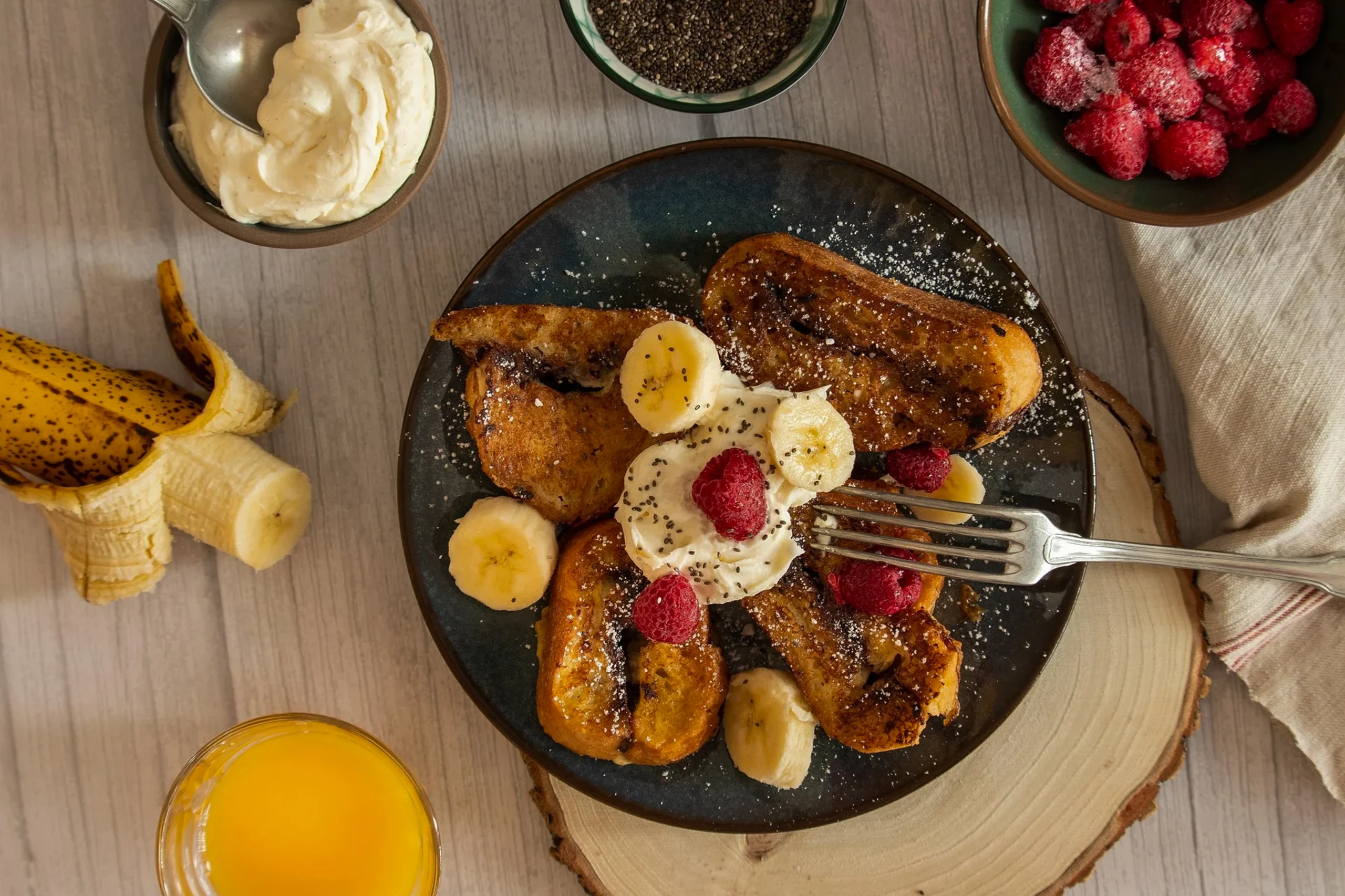 Close-up of thick-cut French toast showing a soft custardy center and crispy caramelized edges on a white plate.
