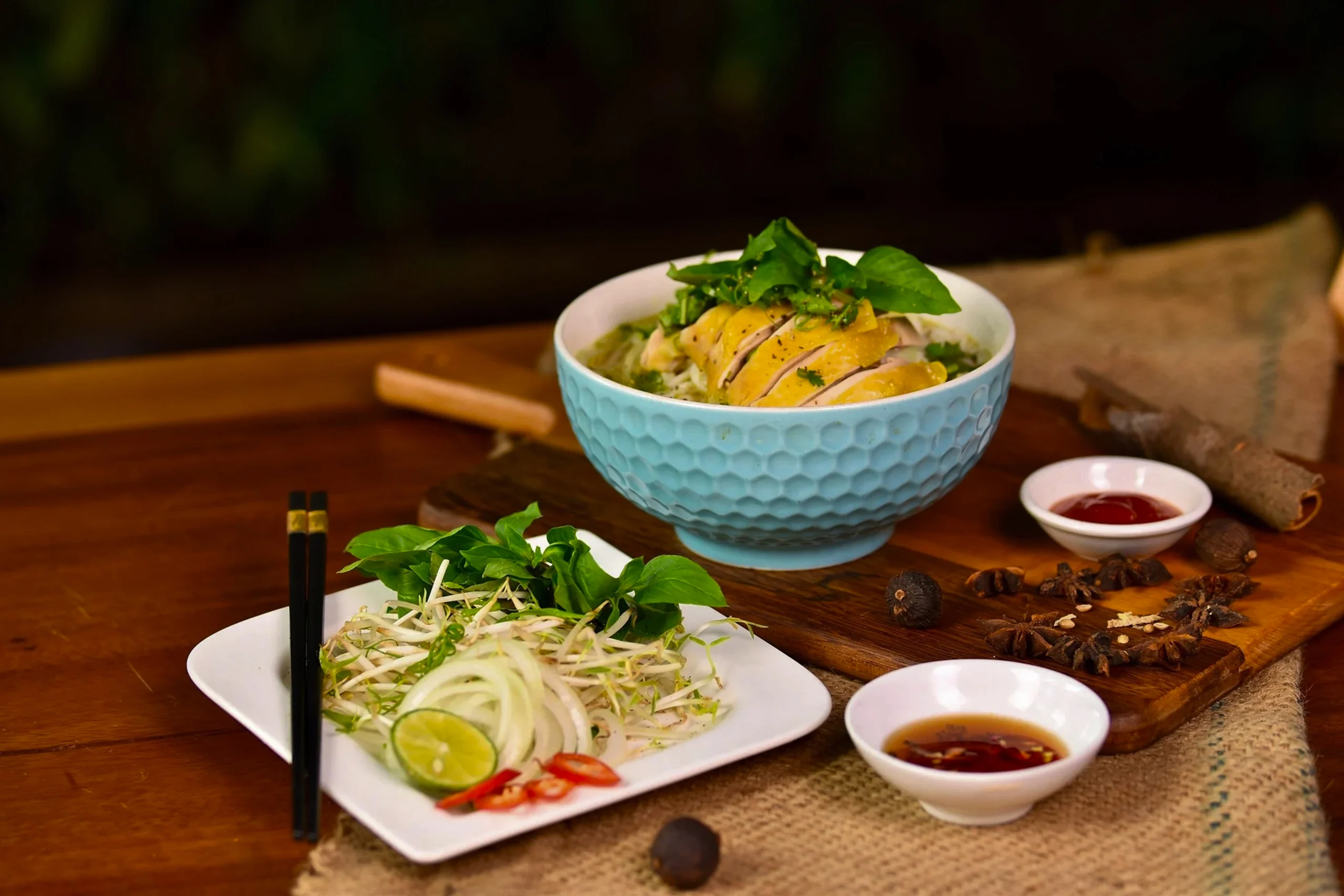 Close-up of a spoonful of golden chicken broth with rotisserie chicken, carrots, celery, and spiral noodles.