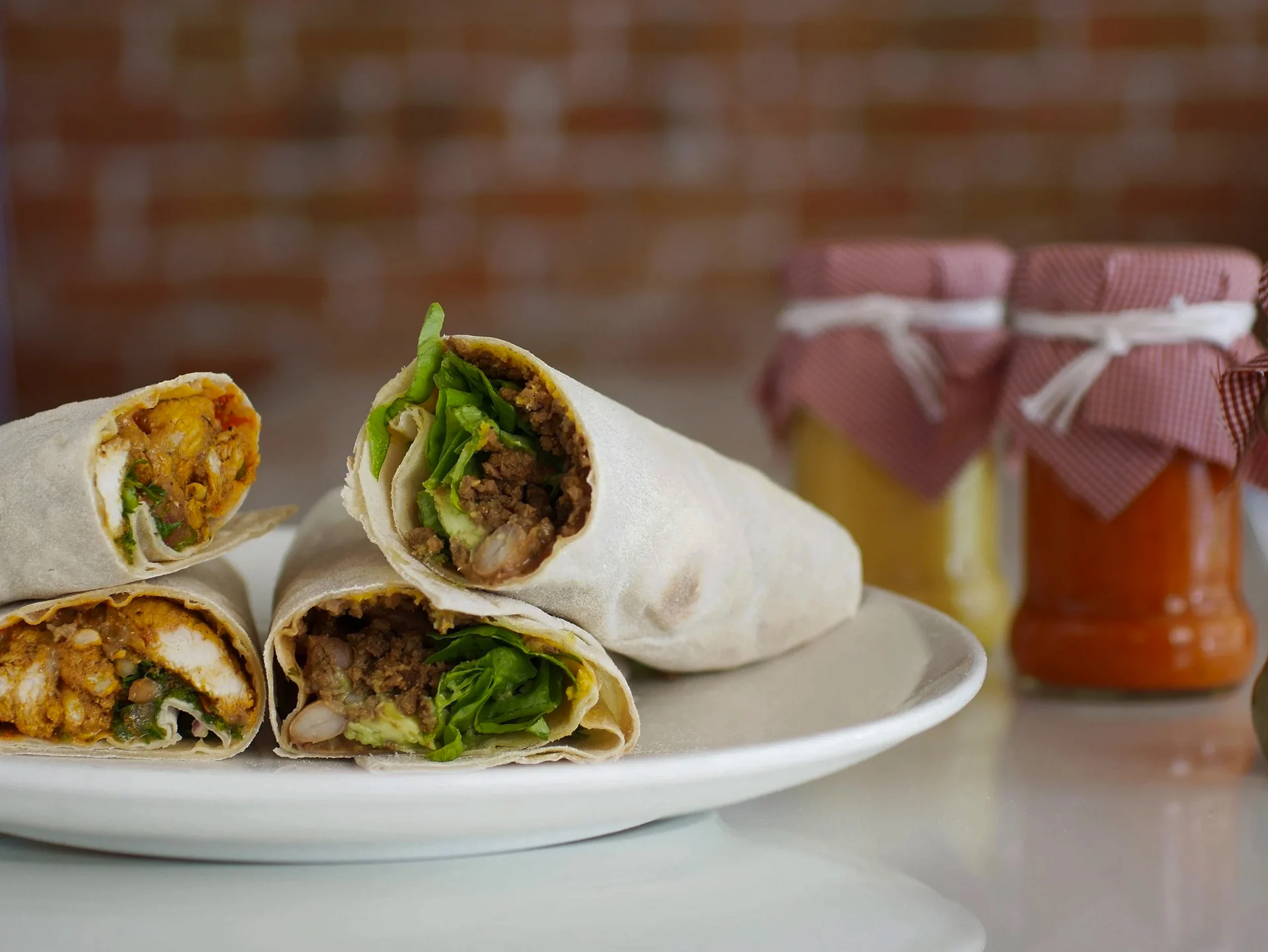 Close-up of a hearty breakfast wrap with black pudding, fried potatoes, and melted cheddar cheese in a flour tortilla.