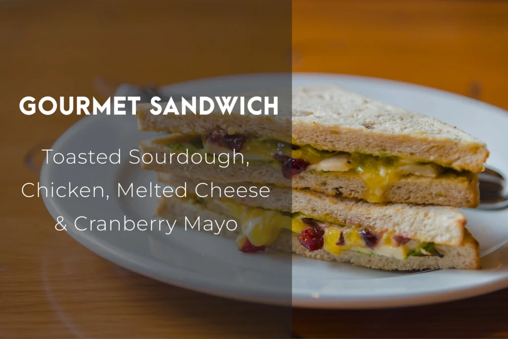 A stacked classic egg sandwich with fluffy scrambled eggs, melted sharp cheddar, and crispy bacon on a toasted brioche bun.