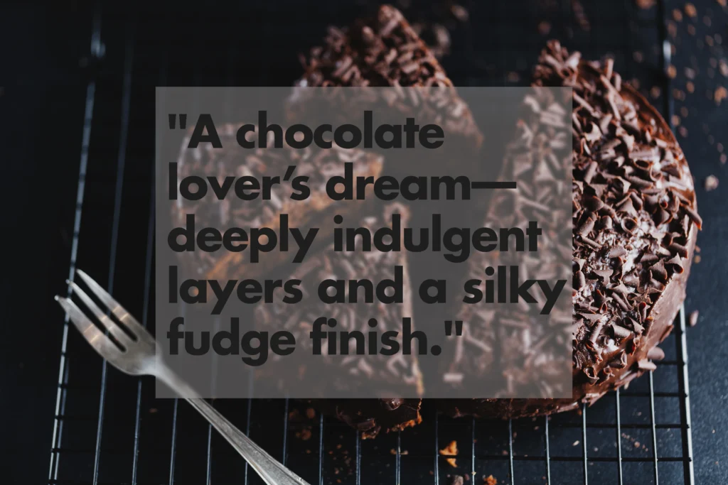 Rich and moist double-layer Chocolate Fudge Cake with swirls of dark chocolate buttercream frosting. A sliced piece shows the dense fudge texture, perfect for a professional dessert recipe blog header