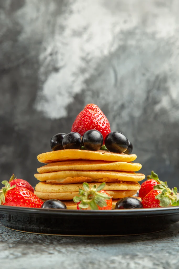 Golden brown American pancakes topped with fresh blueberries and powdered sugar.