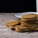 Healthy homemade dark chocolate digestive biscuits made with whole wheat flour and oats. A rustic tea-time snack on a neutral background.