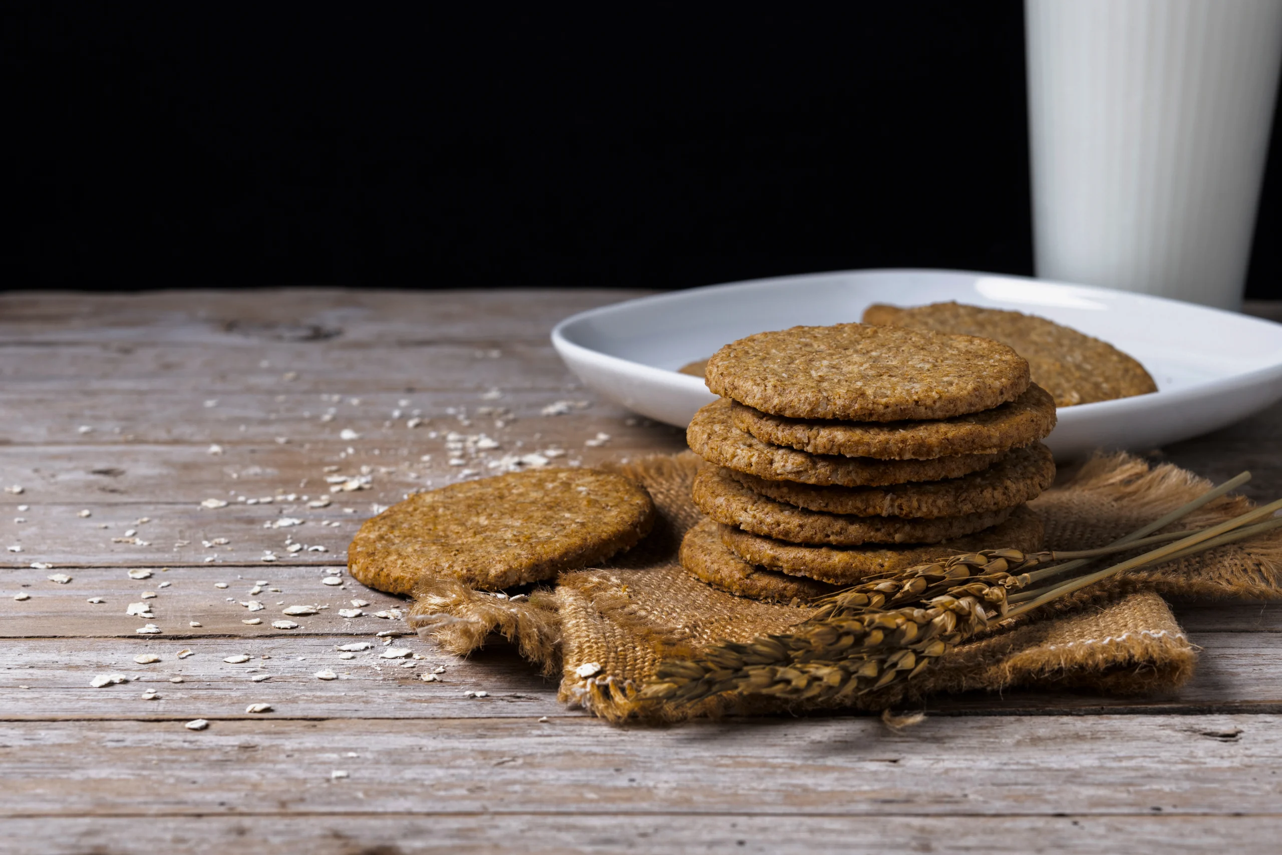 Healthy homemade dark chocolate digestive biscuits made with whole wheat flour and oats. A rustic tea-time snack on a neutral background.