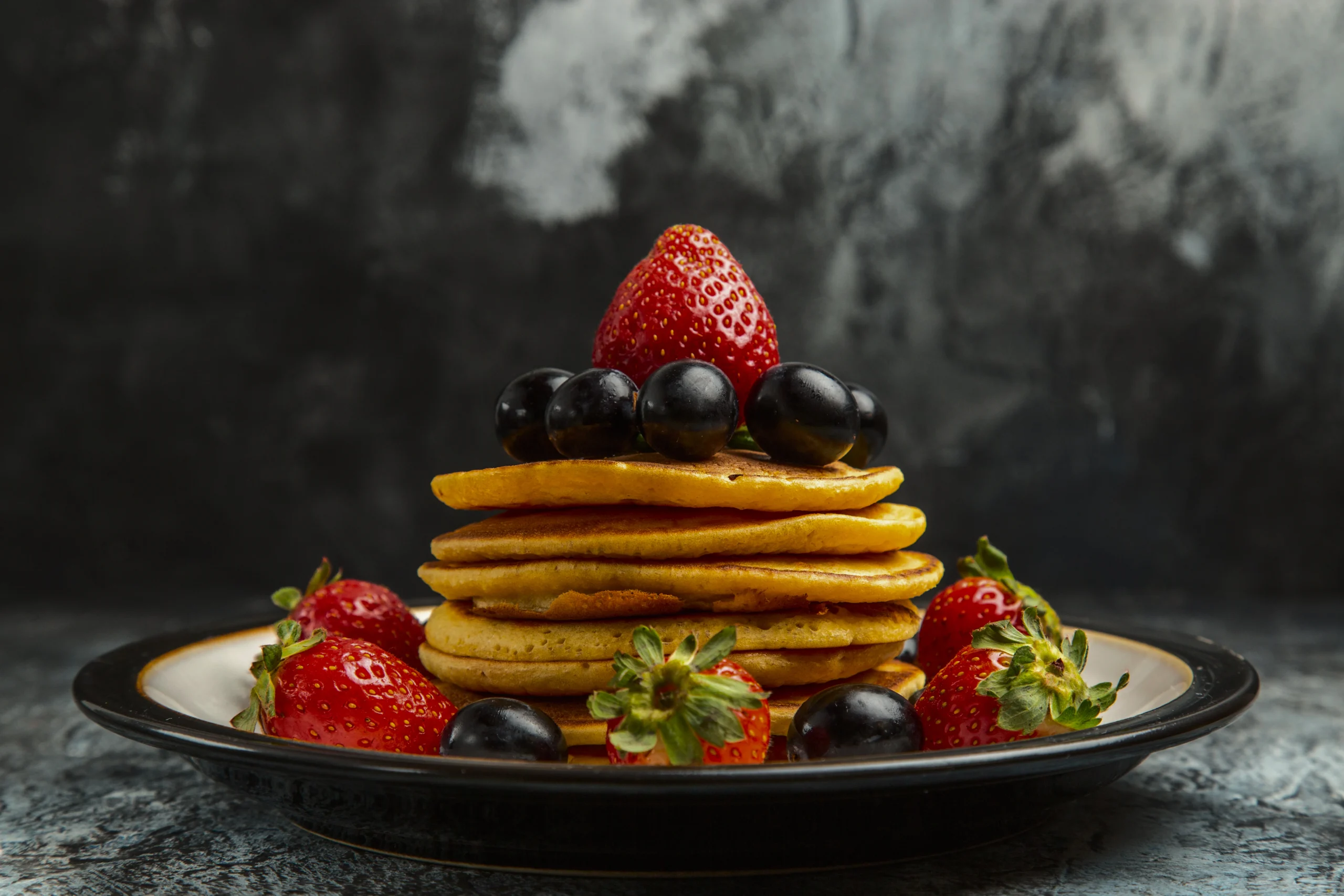 Golden-brown American pancakes cooking on a flat griddle, showing the perfect bubbles forming on the surface