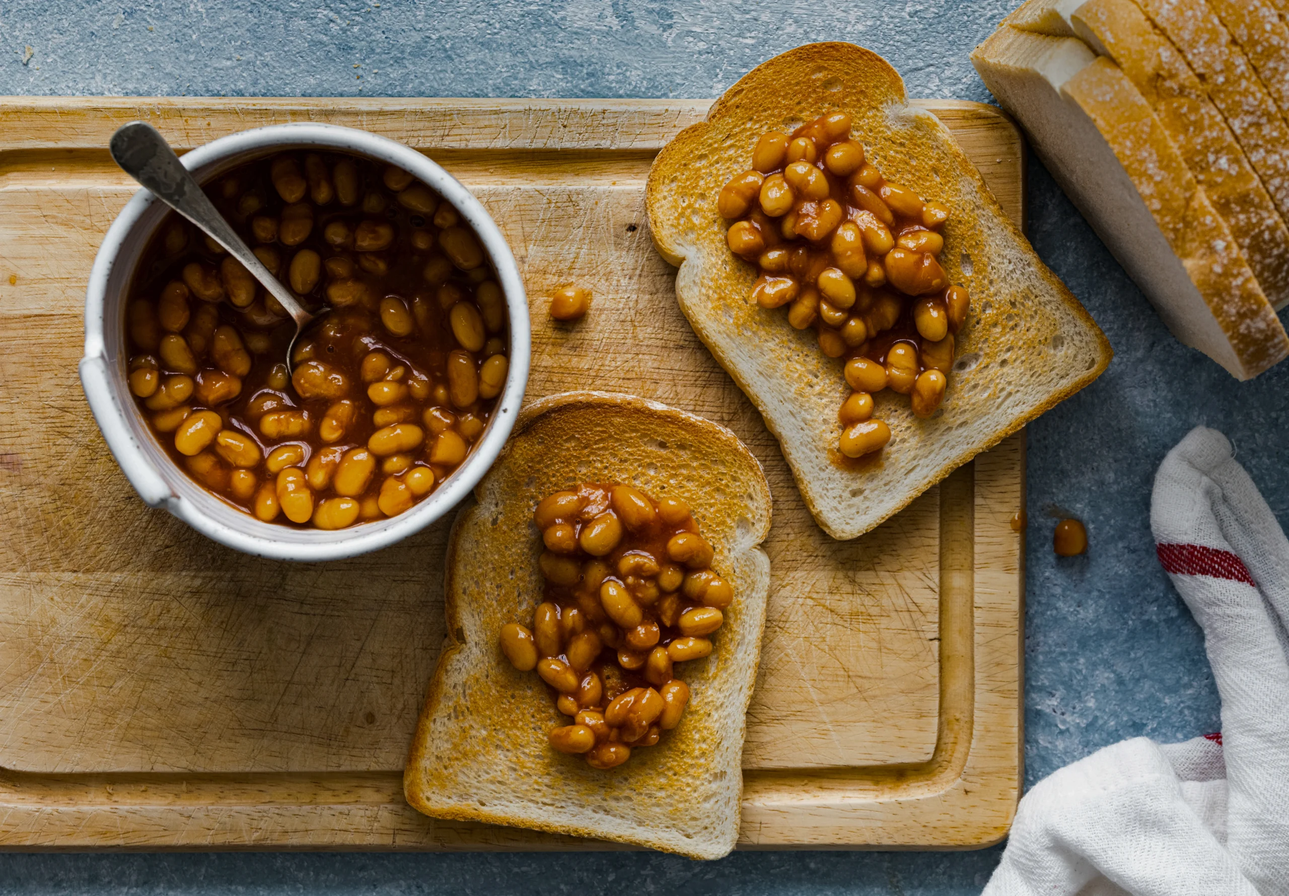 Easy homemade beans on toast served on a white plate, showing the rich tomato sauce soaking into the toasted bread