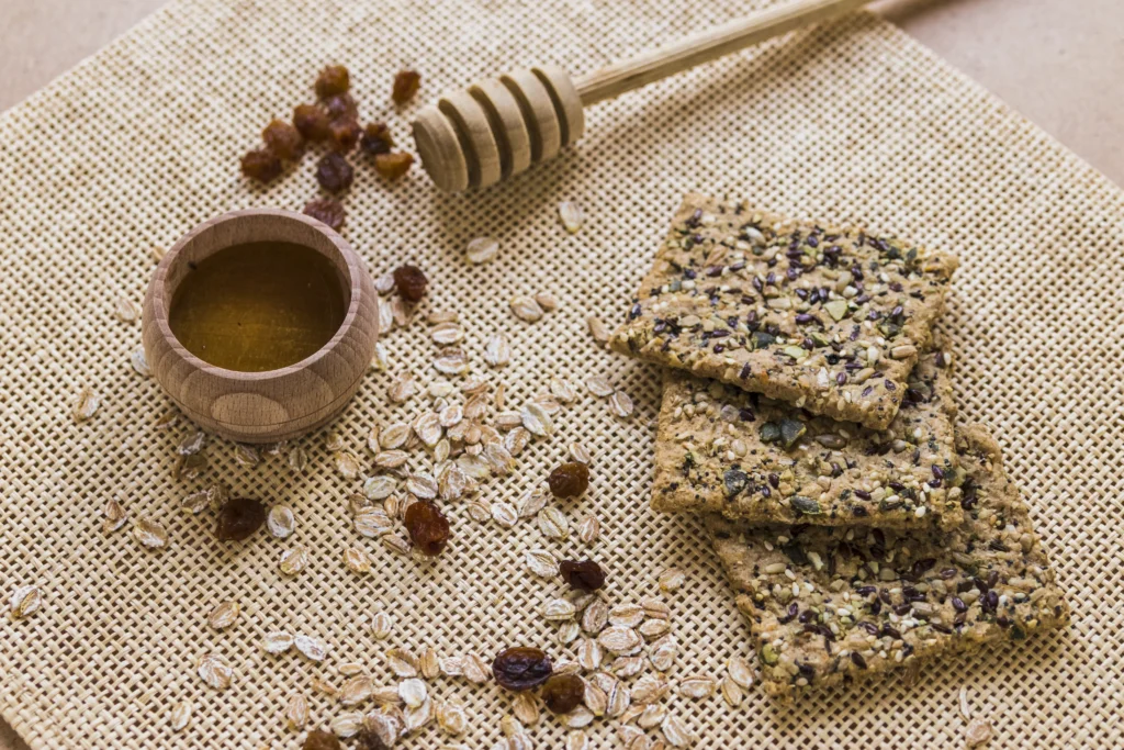 Homemade Manuka honey and toasted oat granola bars with visible pumpkin seeds, dried cranberries, and a golden honey glaze.