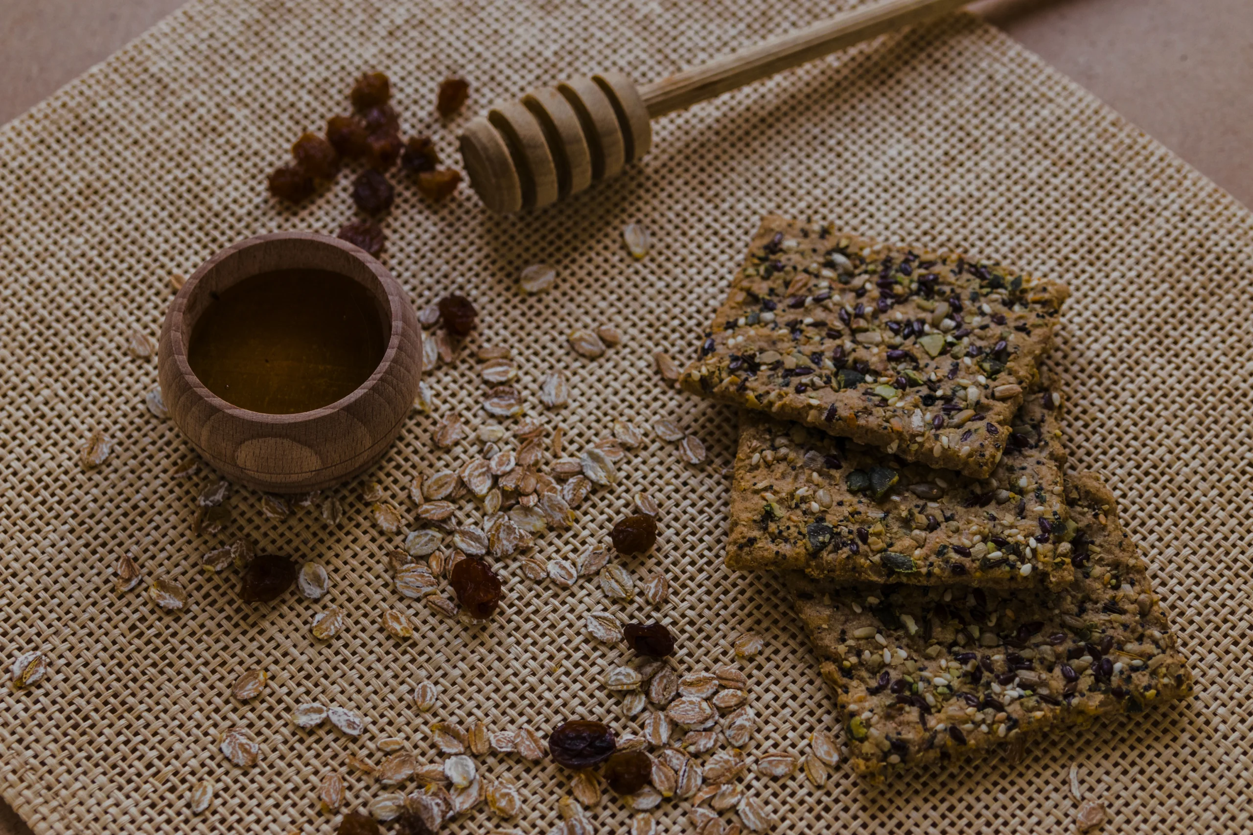 Close-up of a stack of homemade honey oat bars showing whole almonds, flax seeds, and a honey glaze.