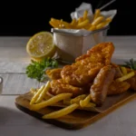 Traditional British fish and chips on a rustic plate with lemon wedges and fresh parsley