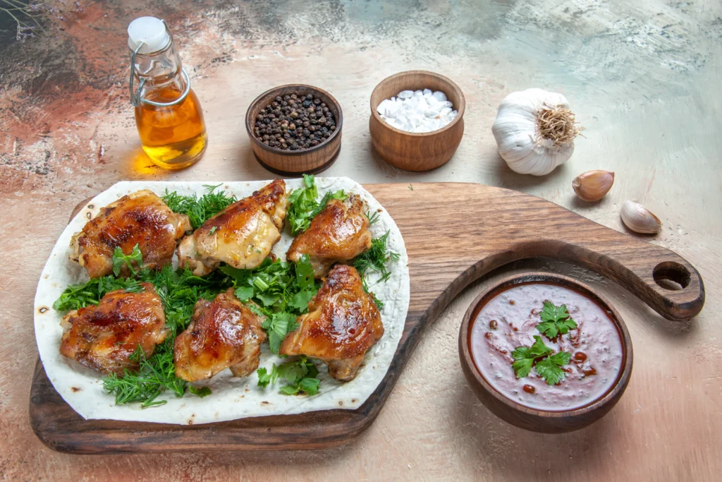 Crispy skin-on spicy garlic chicken thighs glazed in a chili garlic sauce with toasted garlic slivers and fresh red chili garnishes.