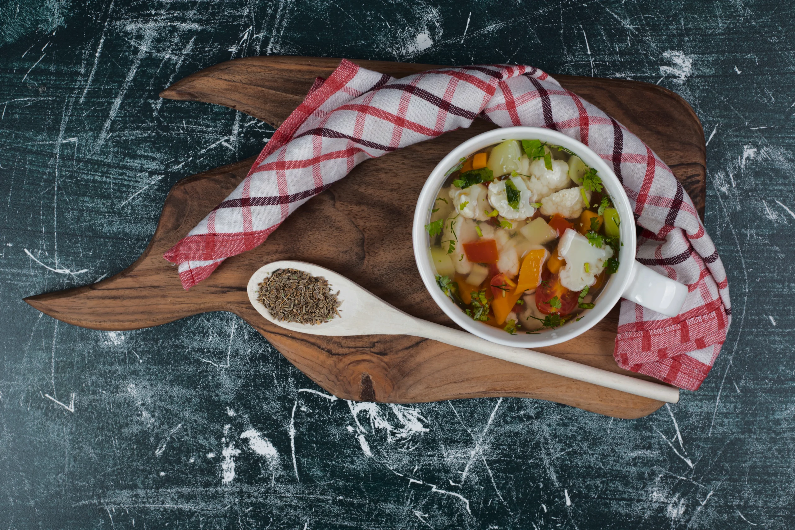 Close-up of hearty vegetable soup served in a rustic ceramic bowl with a side of crusty bread.