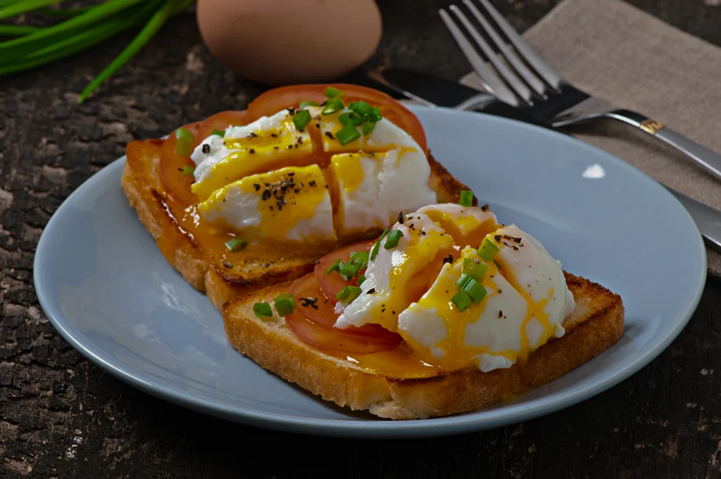 Two perfectly cooked 6-minute soft-boiled eggs with vibrant runny yolks and a stack of golden buttered toast soldiers on a rustic wooden board.