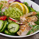 Final plated Grilled Chicken Quinoa Bowl with avocado slices and a light olive oil dressing, perfectly portioned for a healthy 30-minute meal prep lunch.