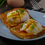 Close-up of a perfectly cooked soft-boiled egg with a jammy yolk and crispy buttered bread strips on a white plate.